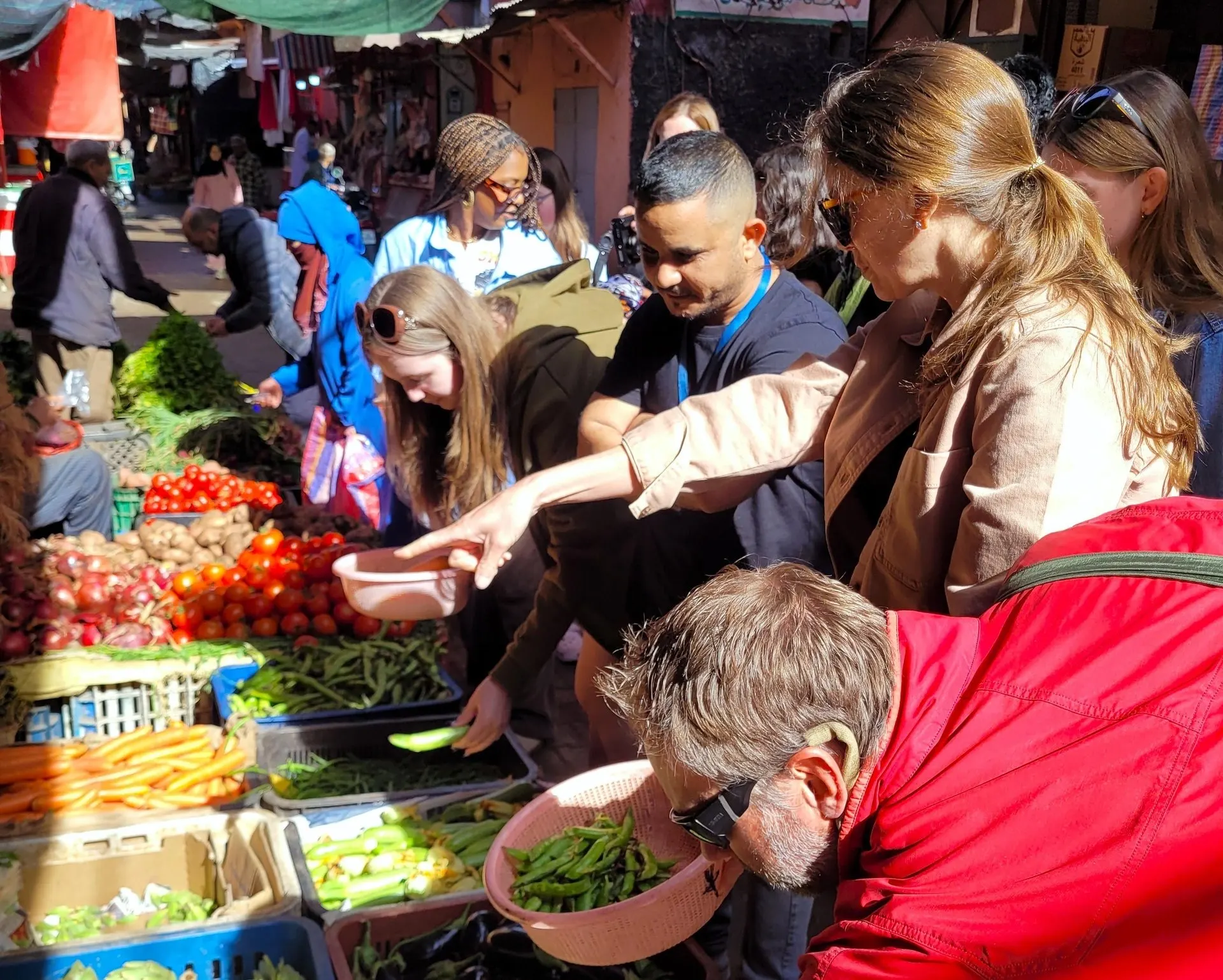 Guests choosing vegetables at a market stall in the Medina with their guide