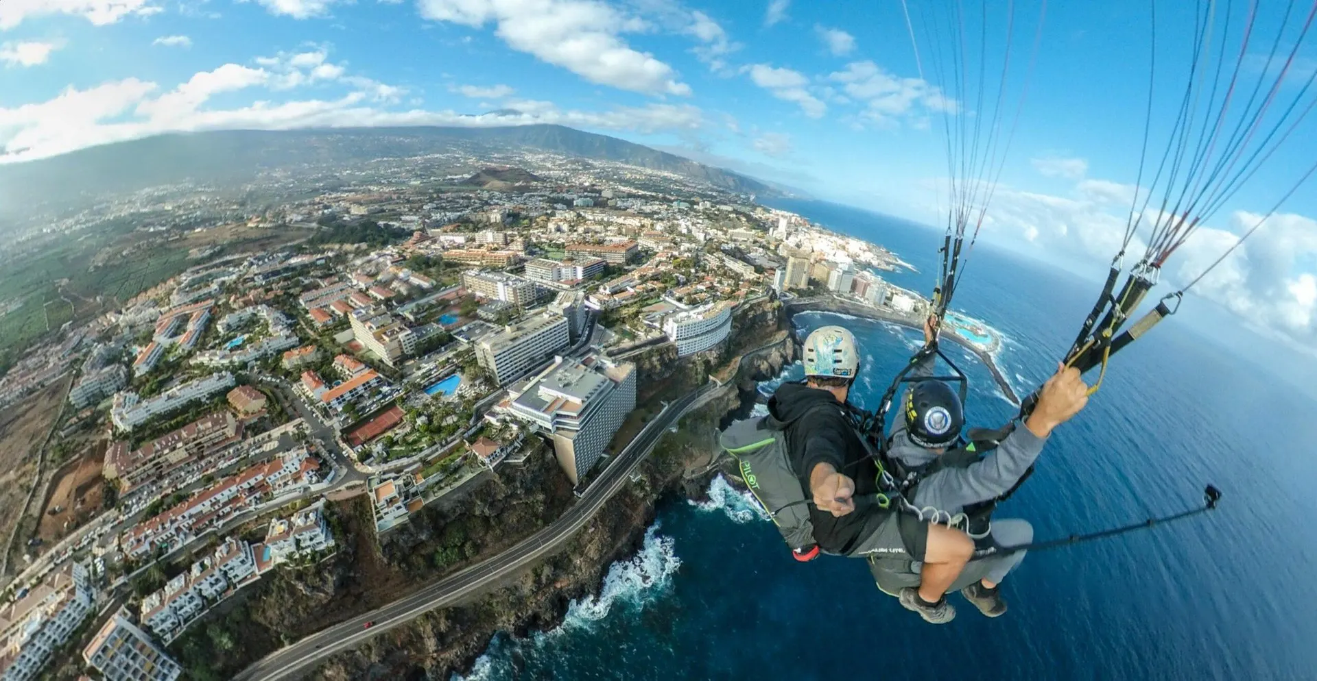 A tandem pilot and passenger over the coast at Puerto de la Cruz