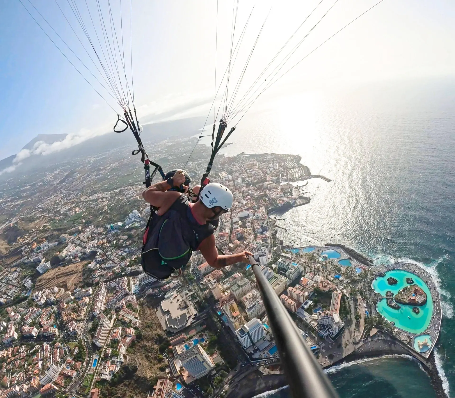 A tandem paraglider over Puerto de la Cruz and the Lago Martiánez pools