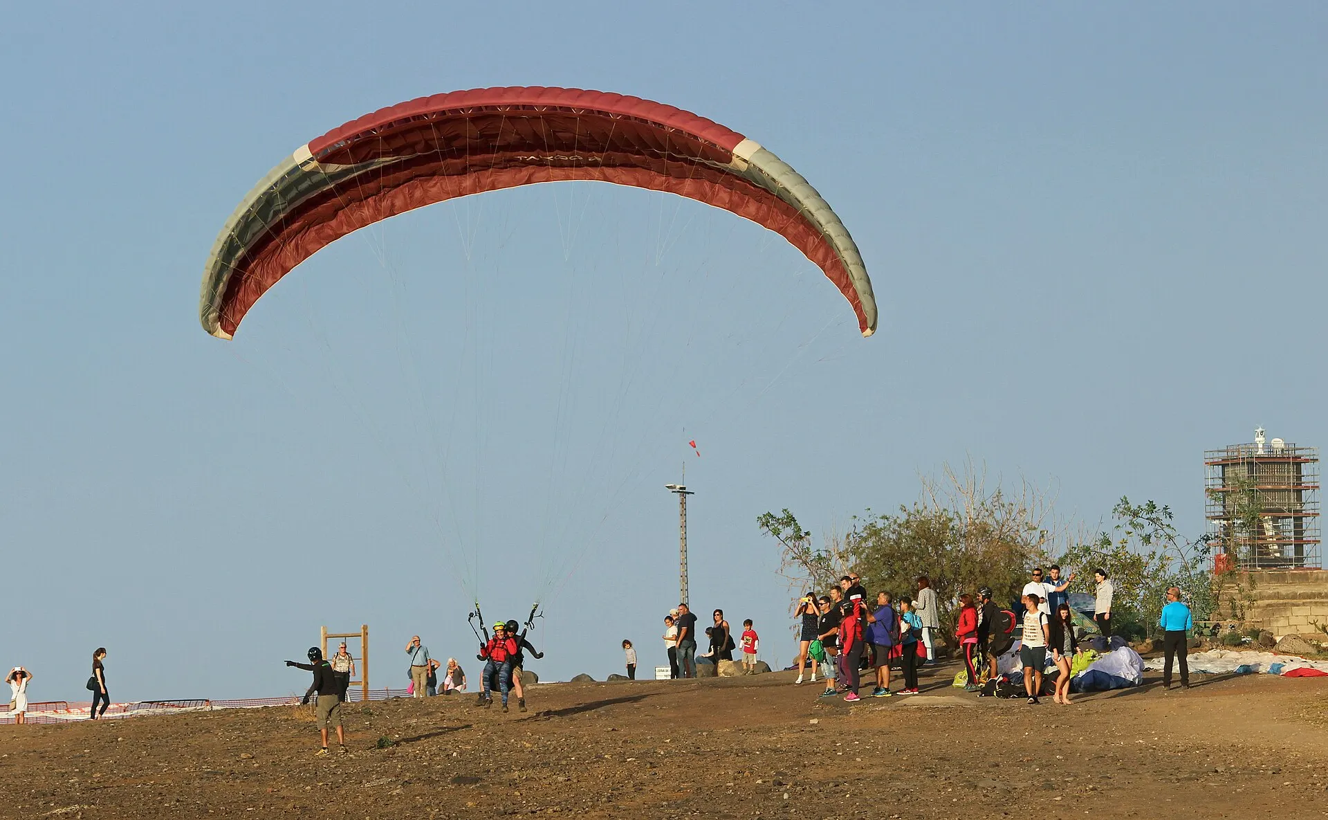 A tandem paraglider coming in to land above the sea at Puerto de la Cruz