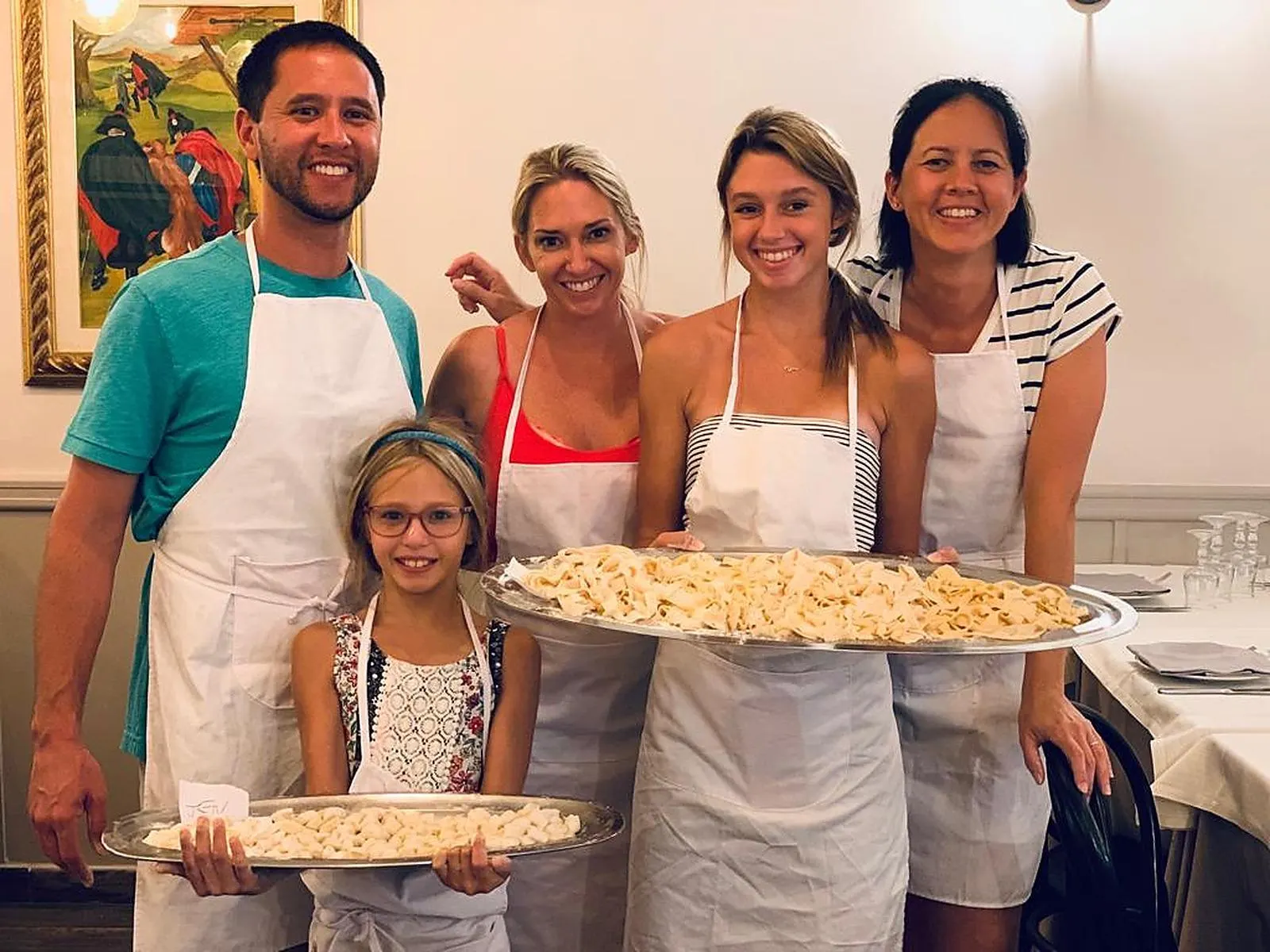 A family showing off their trays of fresh pasta