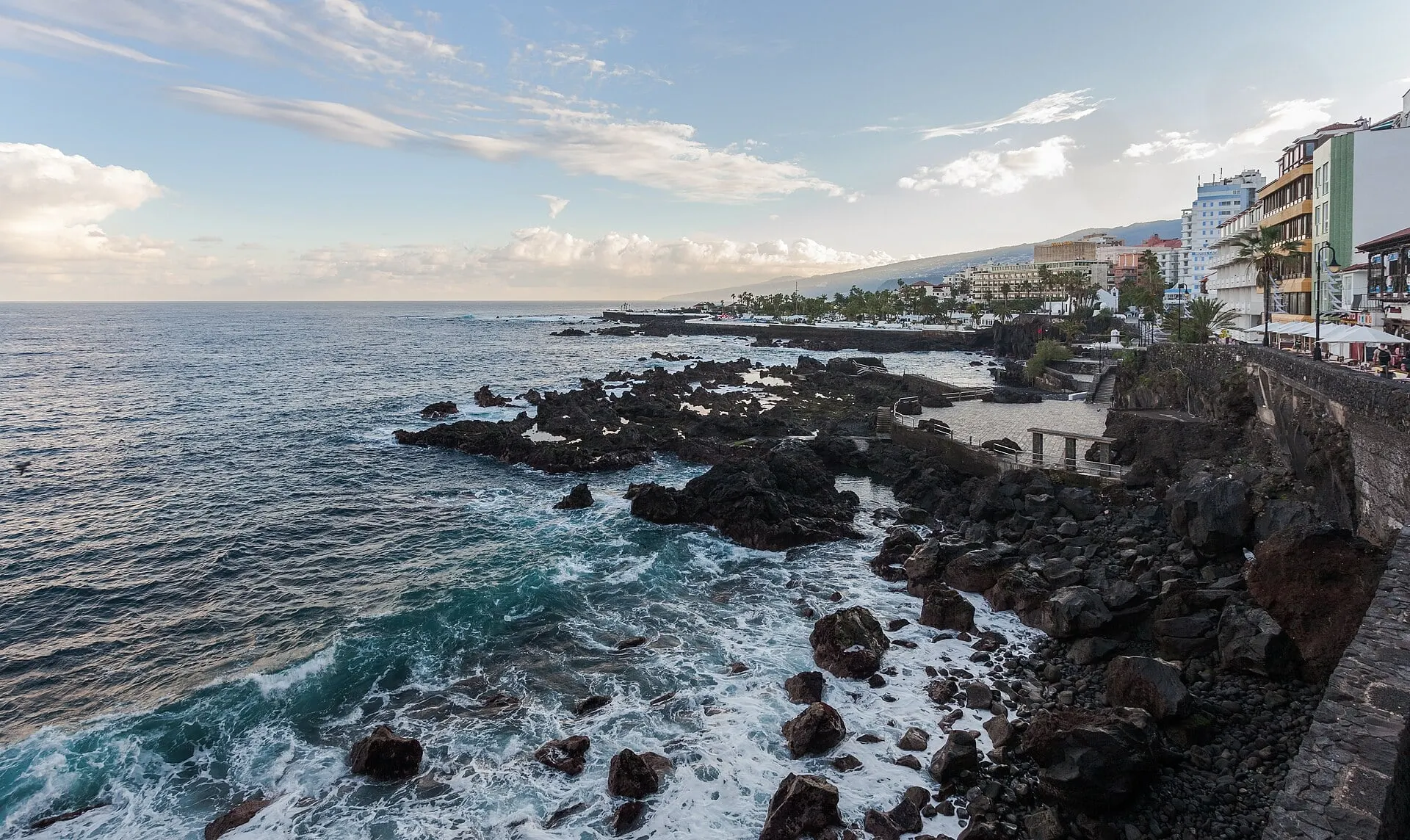 The rocky coast of Puerto de la Cruz in north Tenerife, waves breaking below the seafront in December
