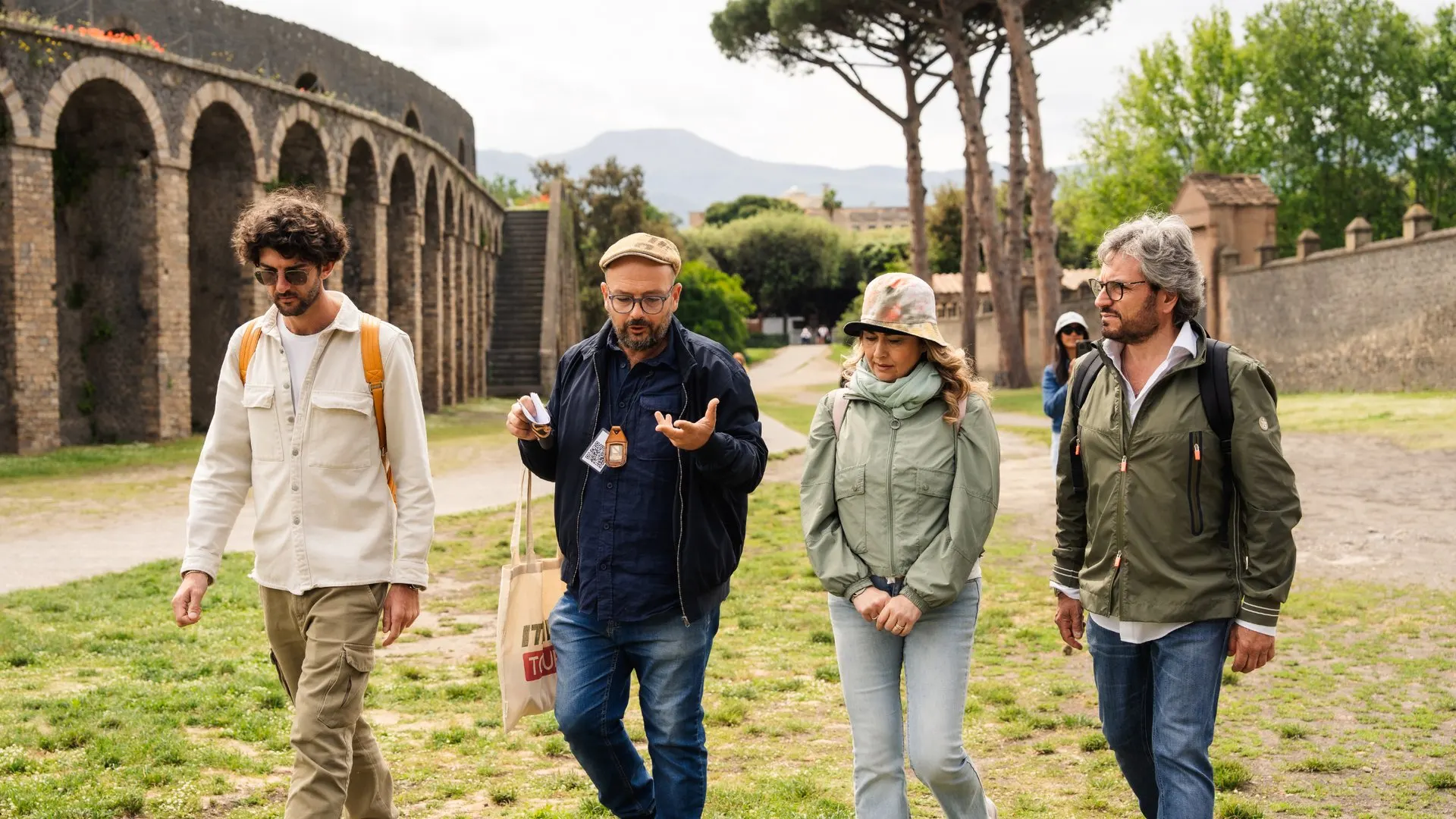A guide leading a group past the walls of Pompeii