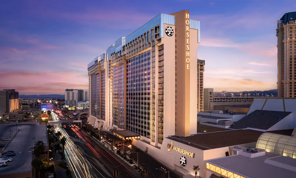 夕暮れのストリップに立つHorseshoe Las Vegasのタワーと、Las Vegas Boulevardを走る車の光跡