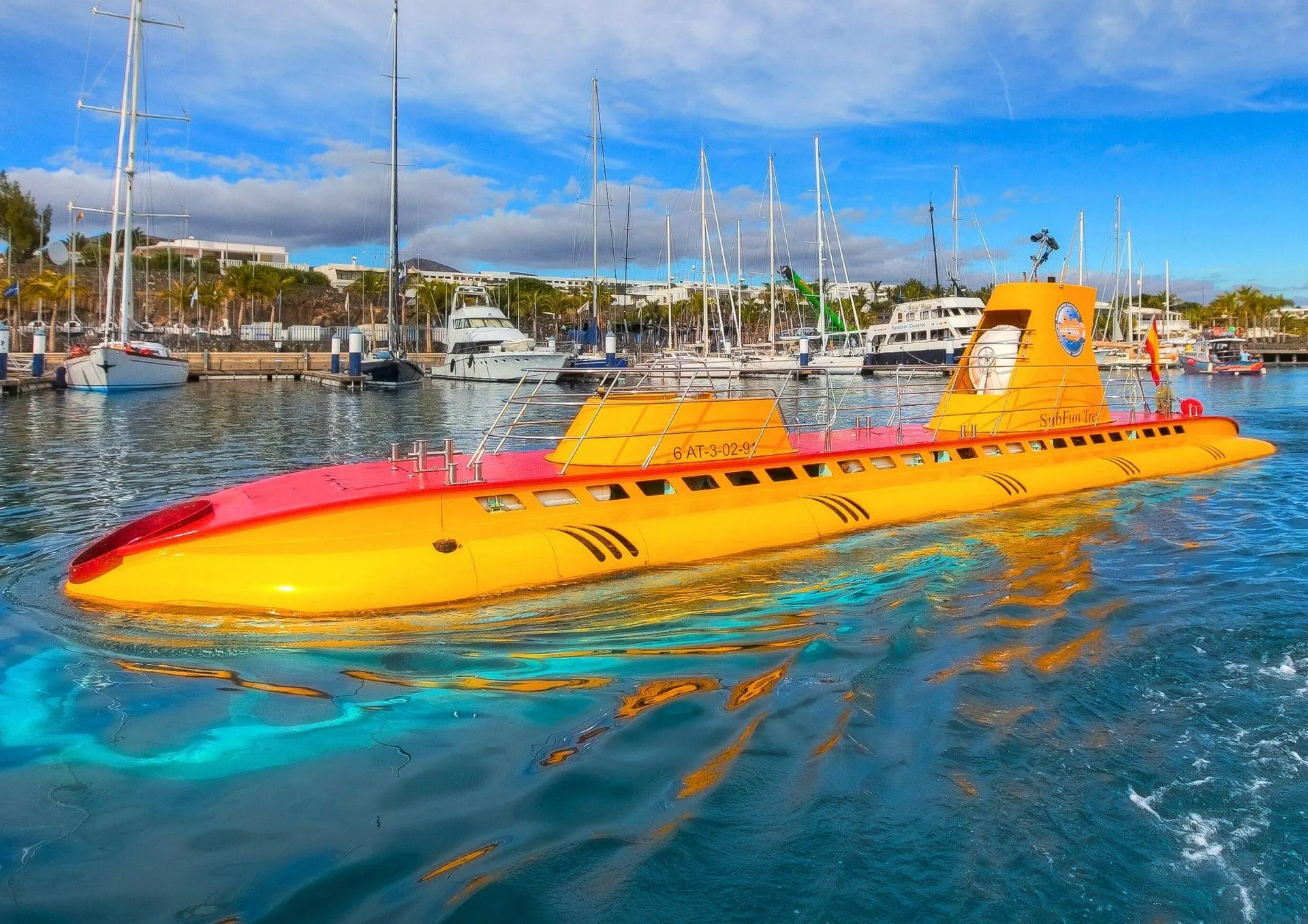プエルト・カレロのマリーナに浮かぶ黄色い潜水艦Sub Fun Tres。背後にヨットが係留されている