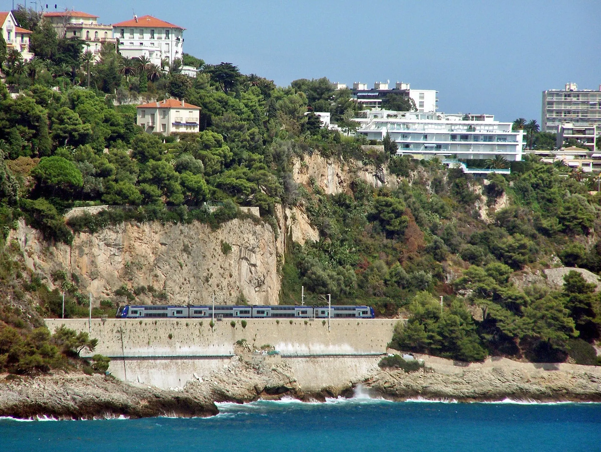 A regional train running along the cliff above the sea at Roquebrune-Cap-Martin.