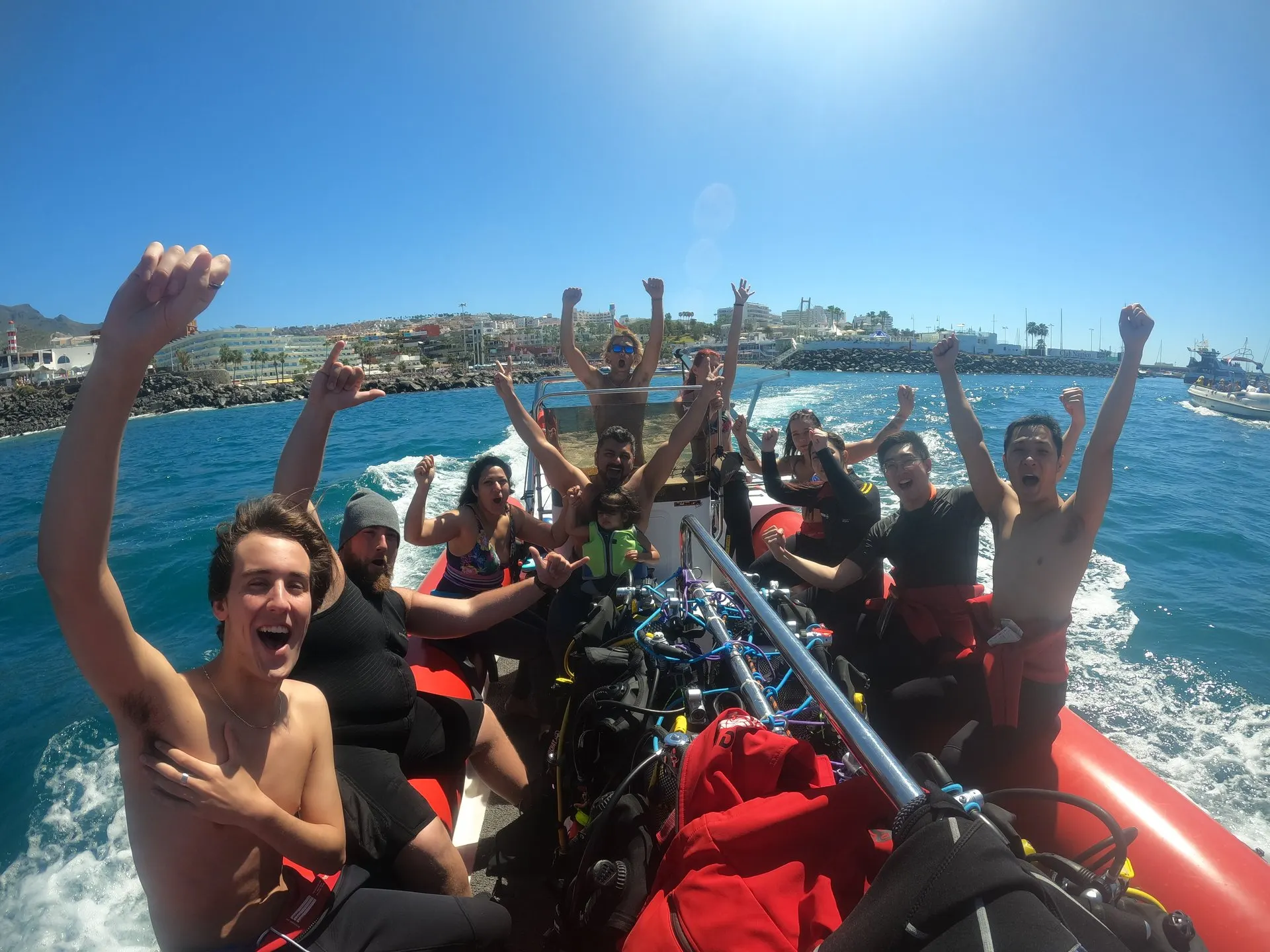 Divers in wetsuits cheering on the speedboat