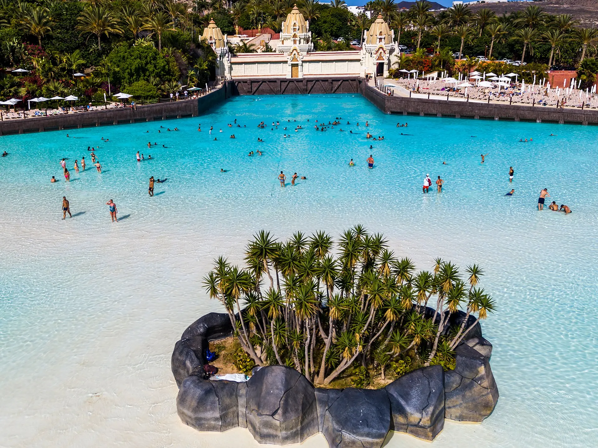 Swimmers in the Wave Palace pool, with the Thai-style palace behind