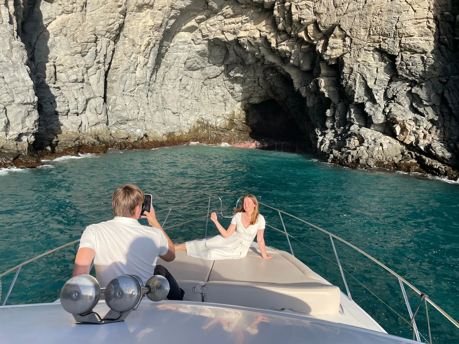 Guests at the bow as the yacht noses into a cove below the cliffs