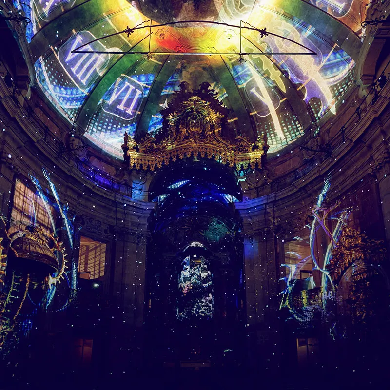 Blue, gold and green projections across the oval dome and walls of the Clérigos Church during Spiritus