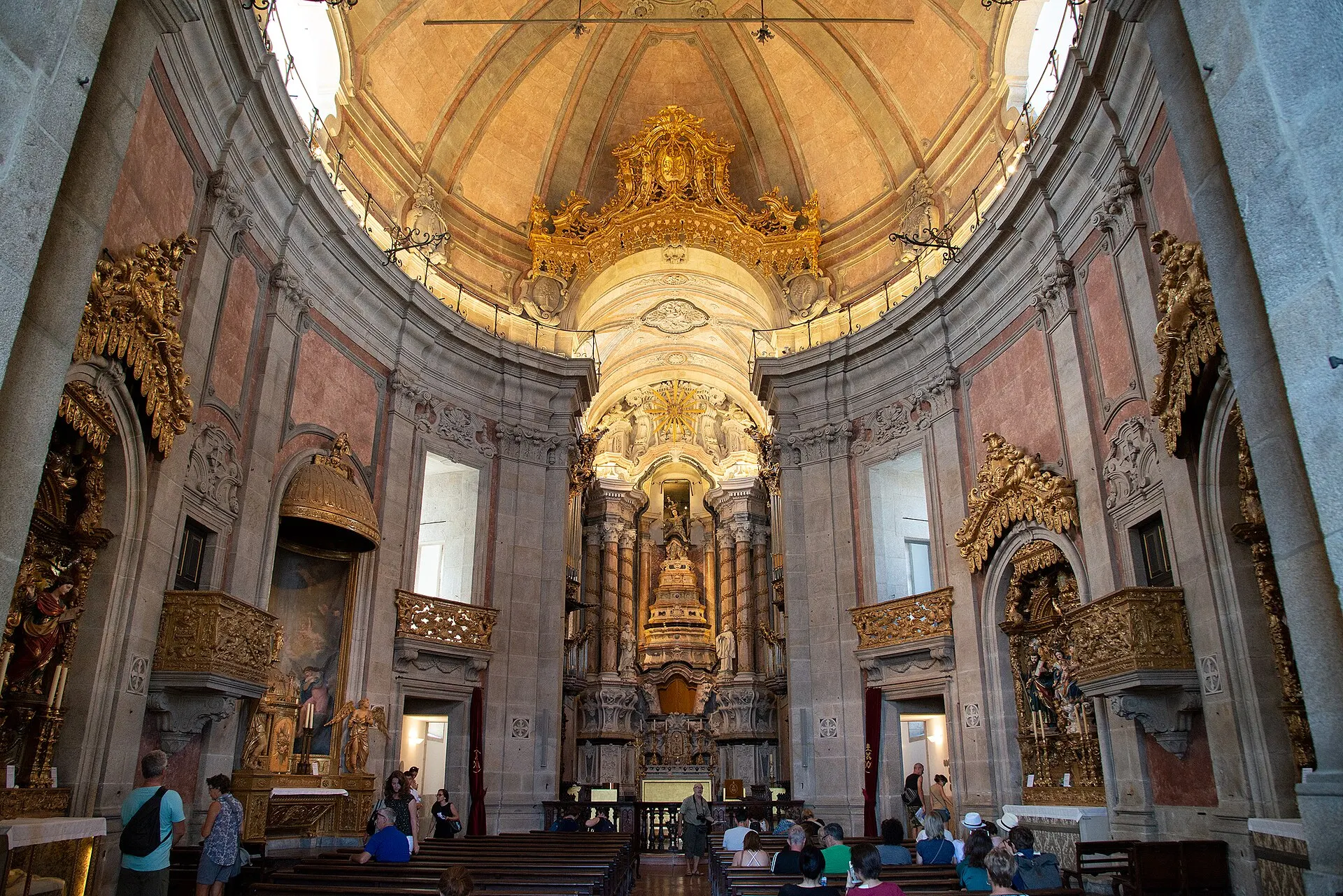The baroque interior of the Clérigos Church by day, looking down the oval nave to the gilded high altar