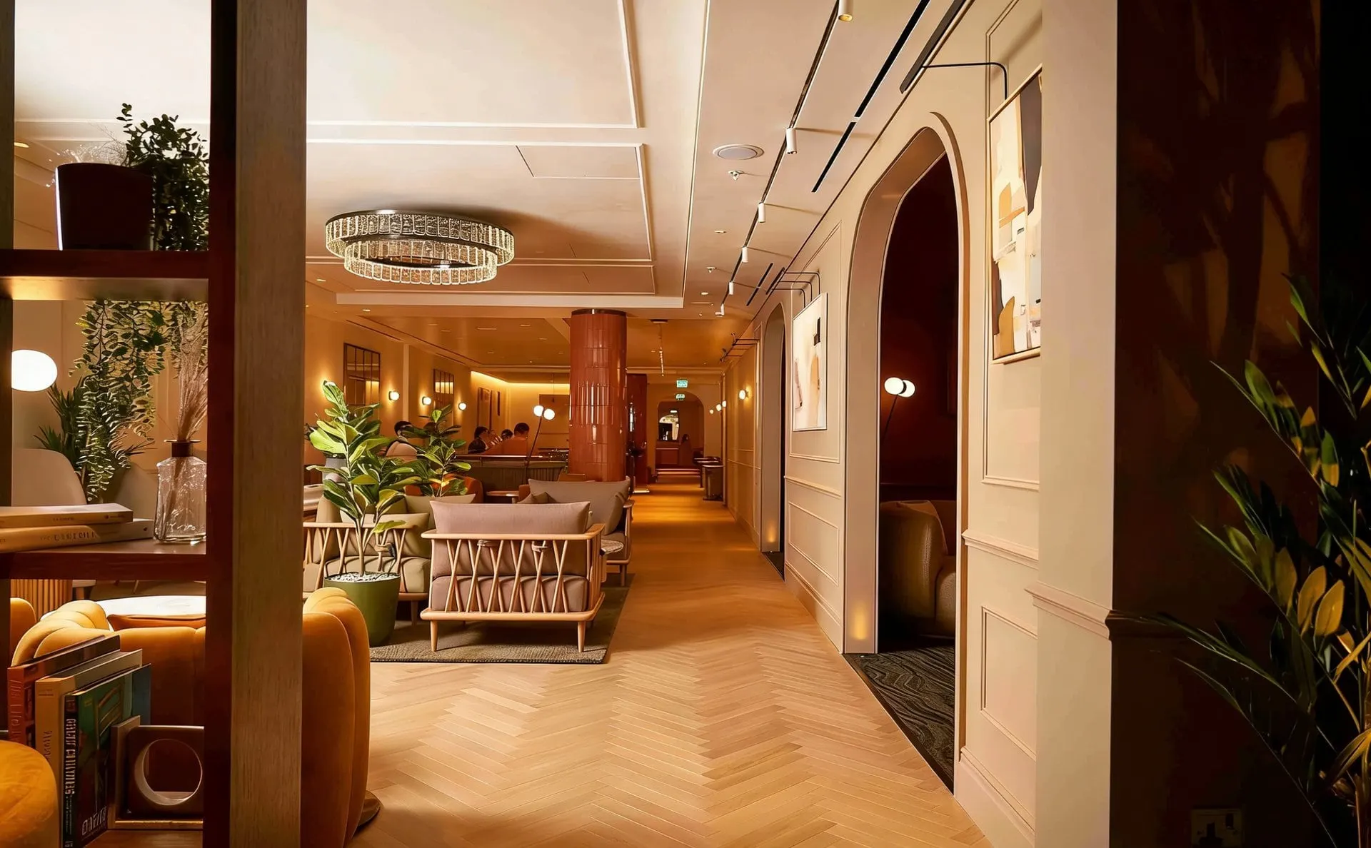 Arched doorway opening onto a long room of armchairs and a herringbone wooden floor