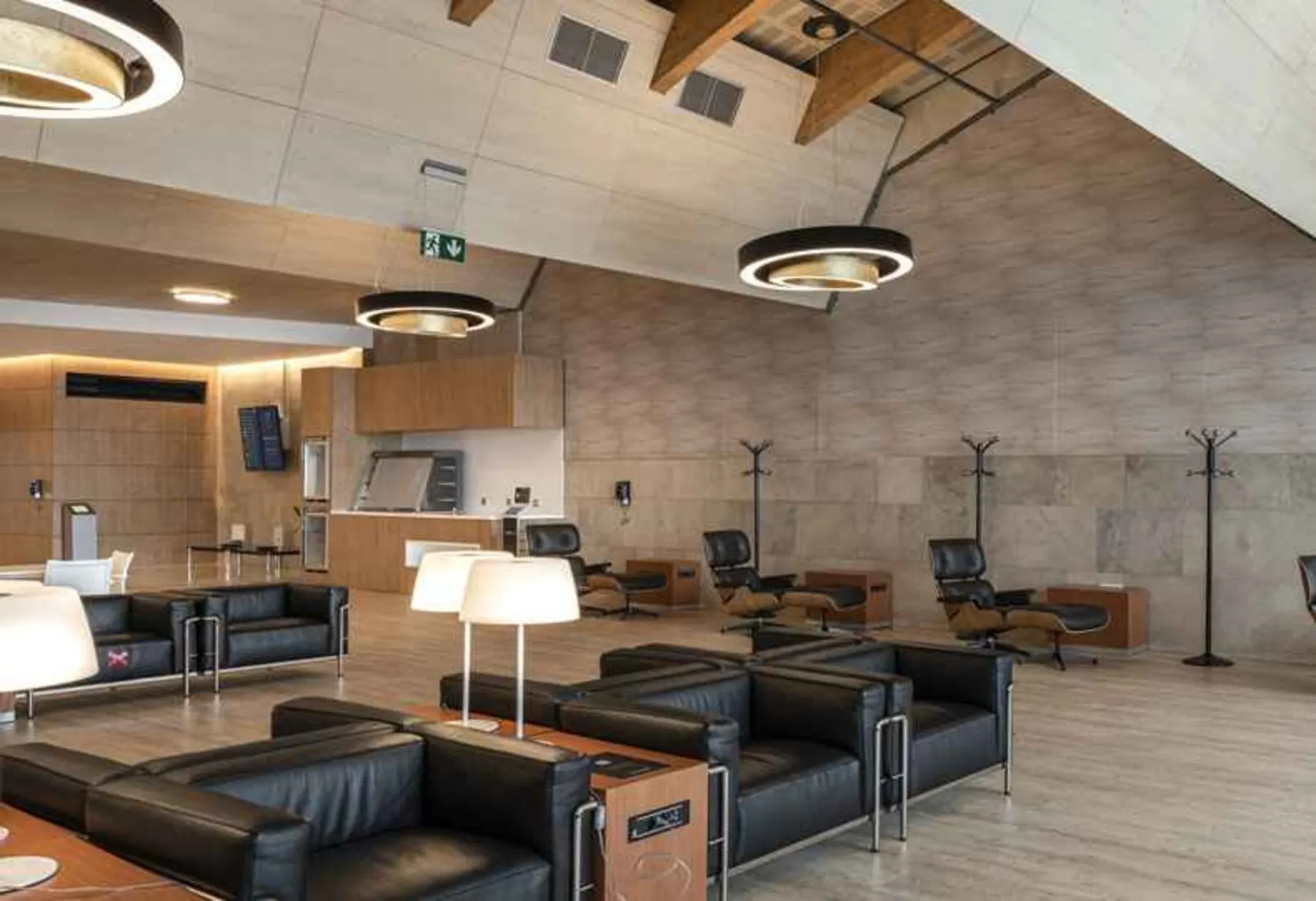 Black leather sofas and armchairs with white lamps under circular ceiling lights in the Nivaria lounge