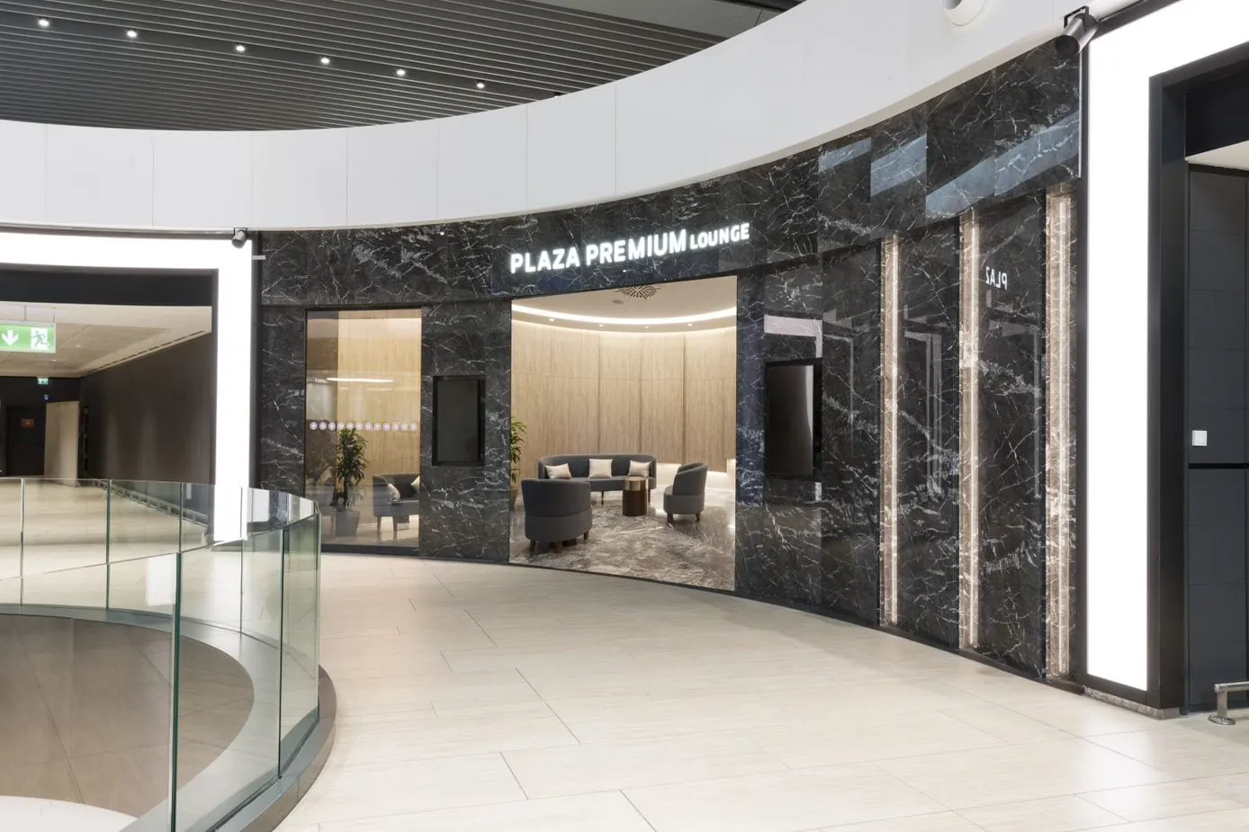 Plaza Premium Lounge entrance with dark marble walls and a glass balcony rail