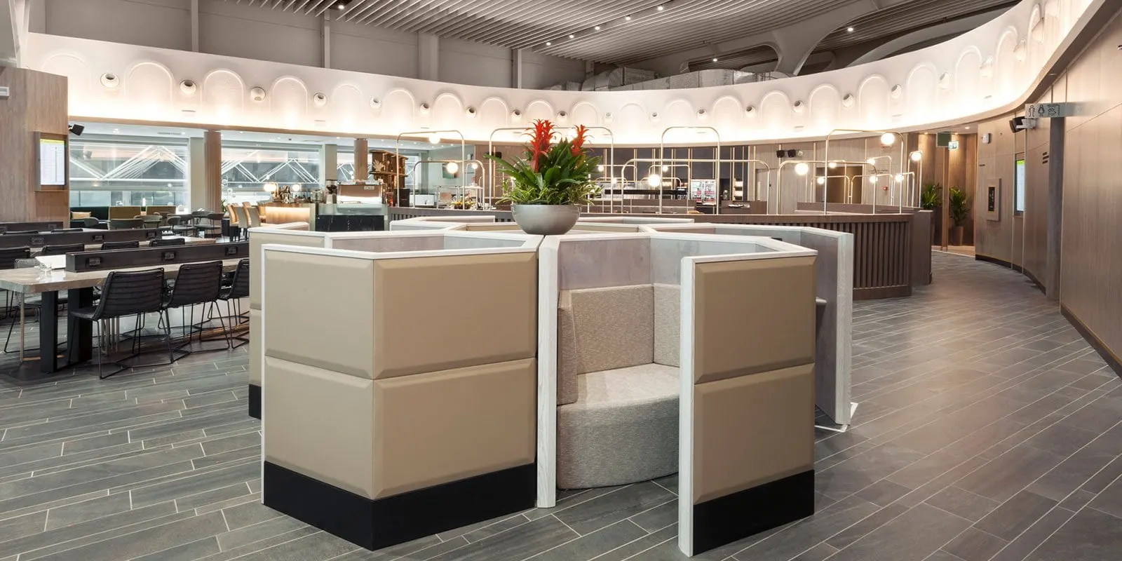 High-backed privacy booths in cream upholstery with a red flower arrangement
