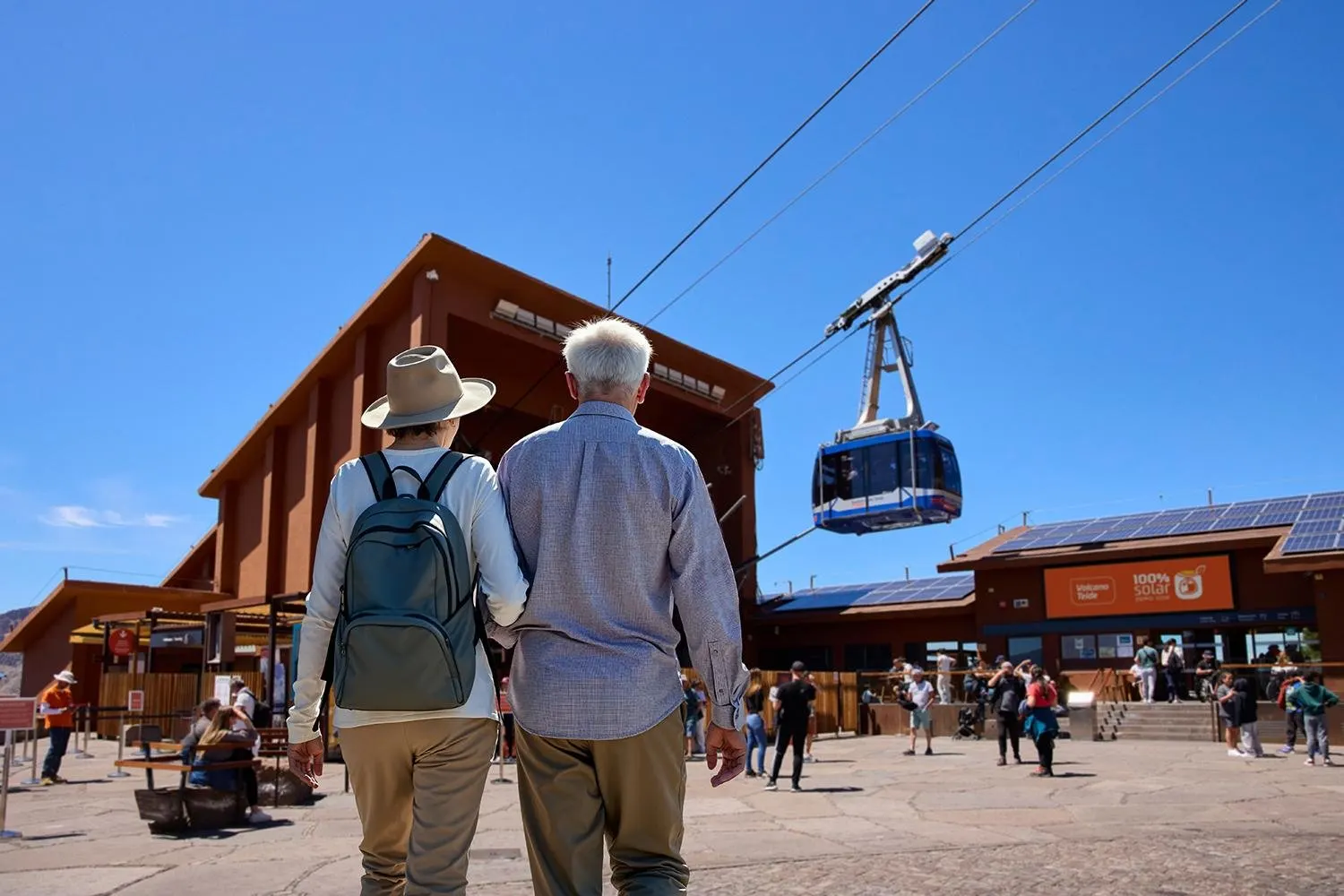 Visitors walking to the Teide cable car base station as a cabin climbs overhead