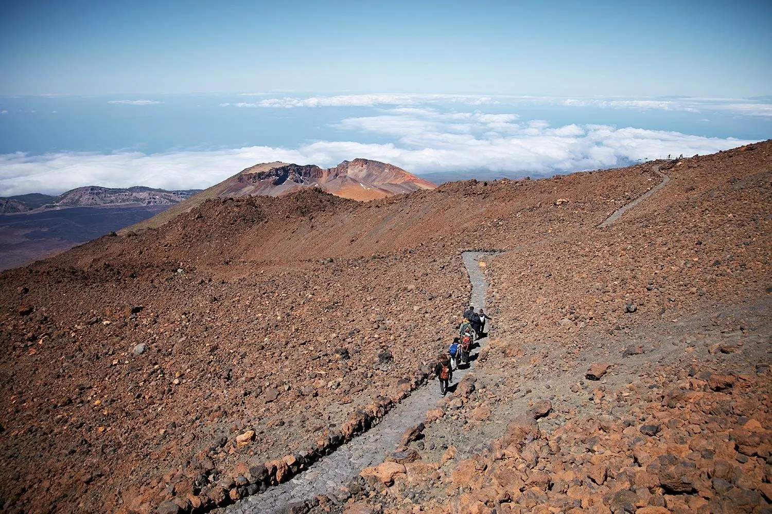 A trail across the lava slopes near the top of the cable car, above the clouds