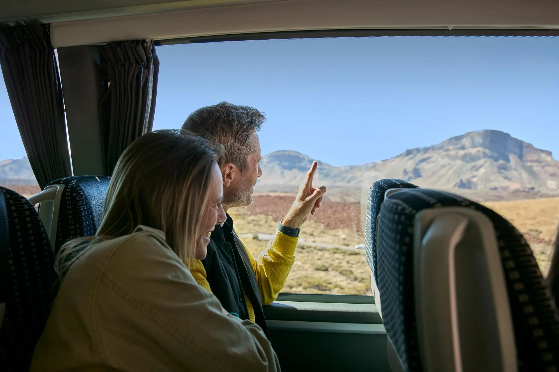 Passengers looking out at the Teide landscape from the coach window