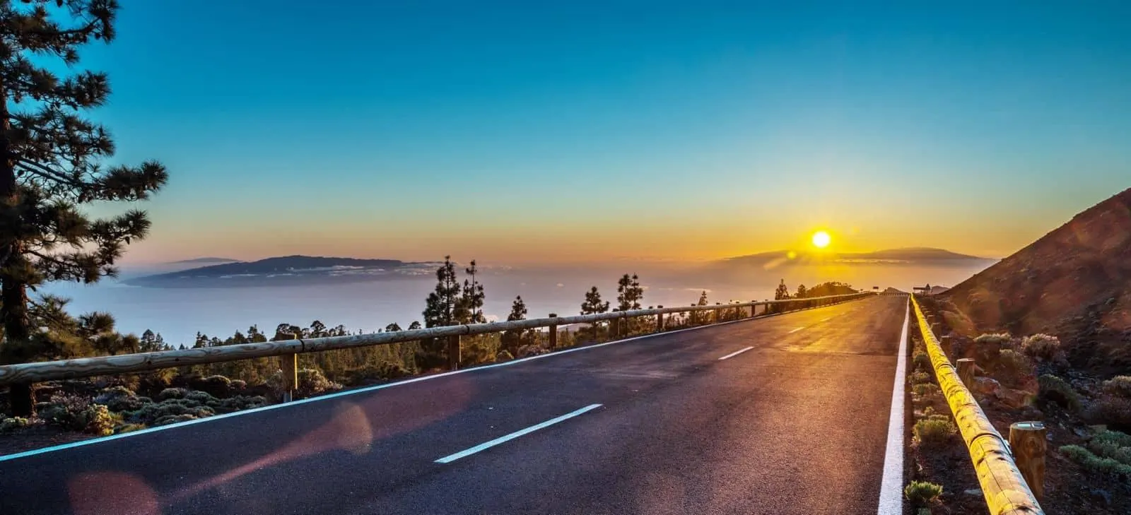 The sun setting over the sea of cloud beside the mountain road through Teide National Park