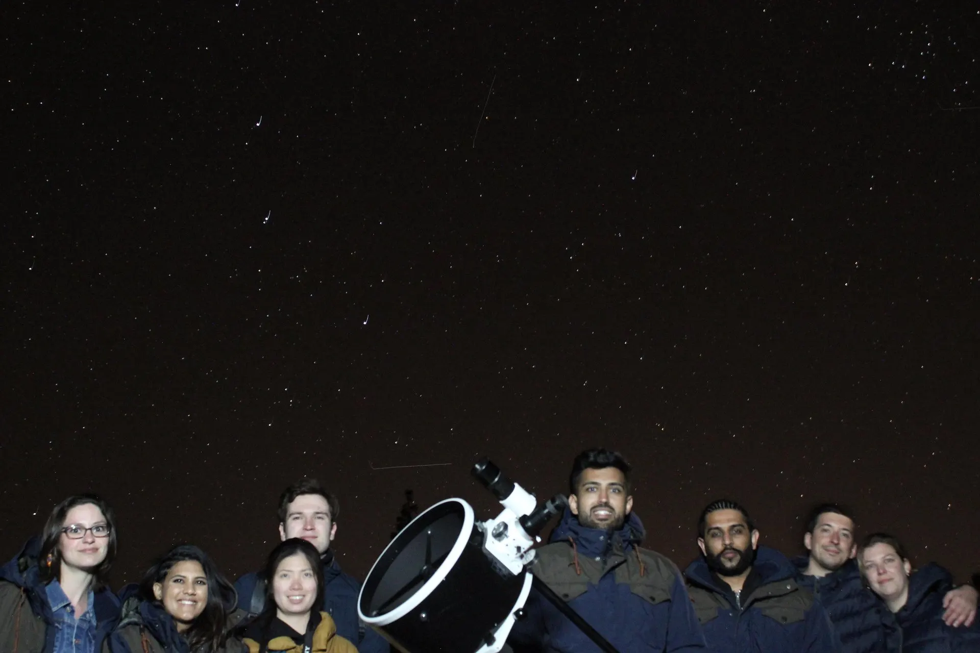 A tour group gathered round a telescope under the night sky in Teide National Park