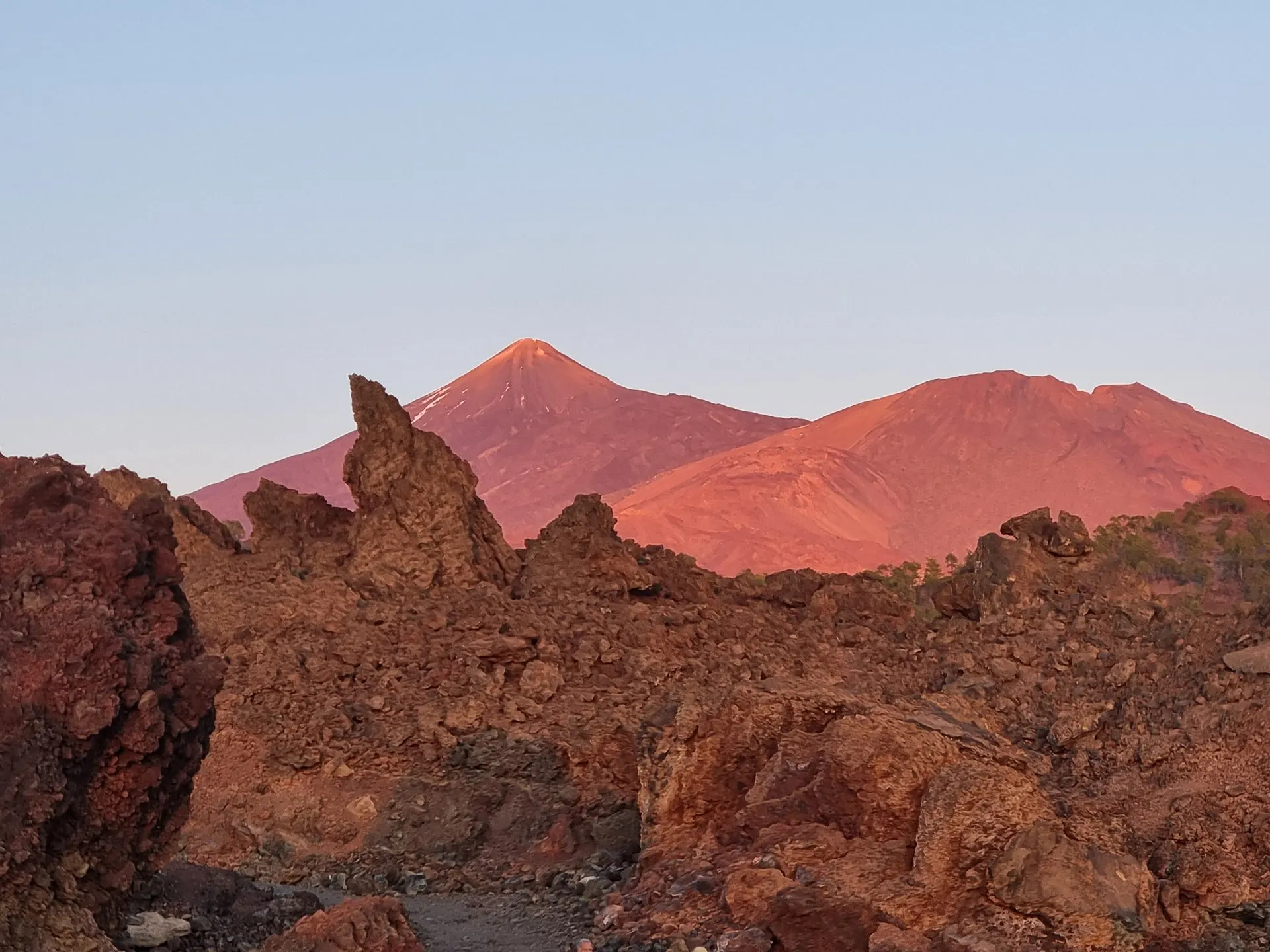 La cima del Teide che si tinge di rosso al crepuscolo sopra le rocce laviche di Las Cañadas