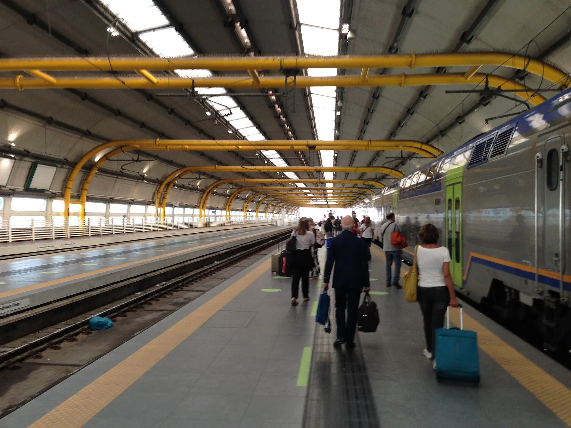The platforms of Fiumicino Aeroporto station, under its yellow arched roof