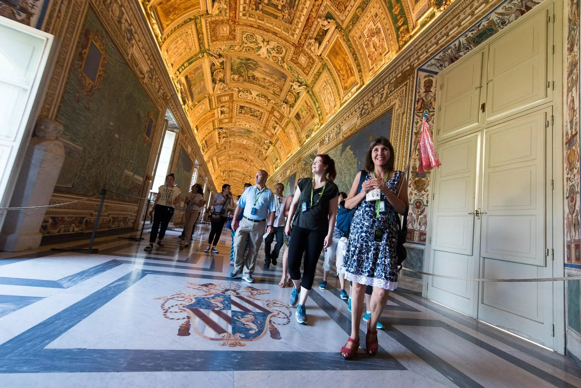 A small group walking through the Gallery of Maps in the Vatican Museums