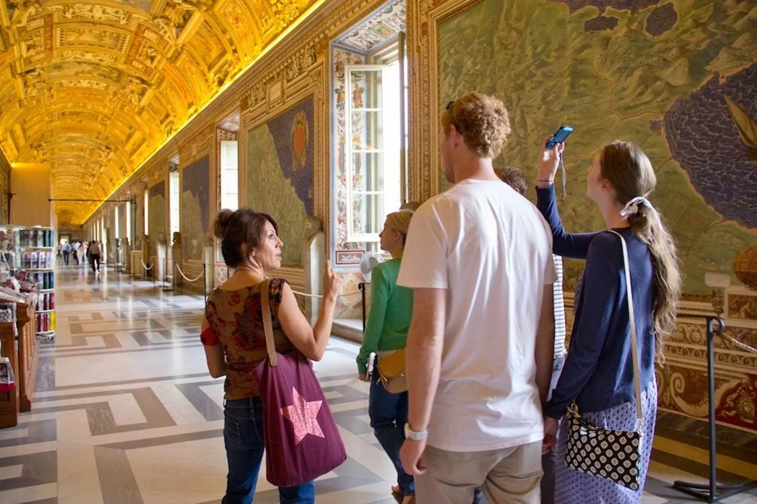 Visitors looking up at the painted ceiling of the Gallery of Maps