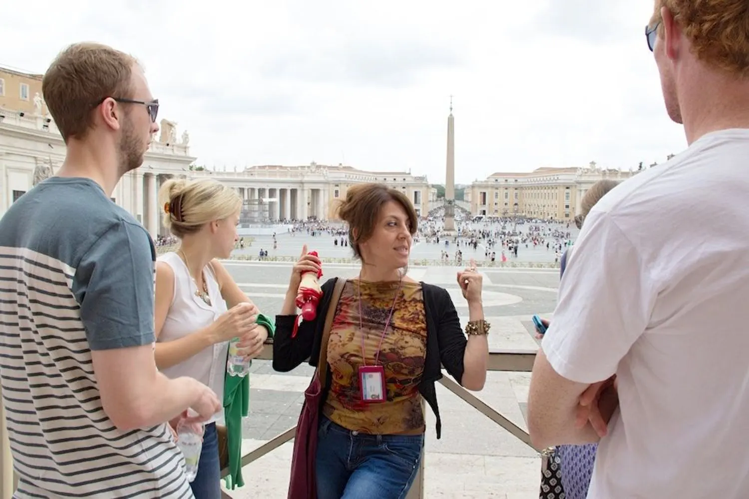 A guide with a group on a balcony above St Peter's Square