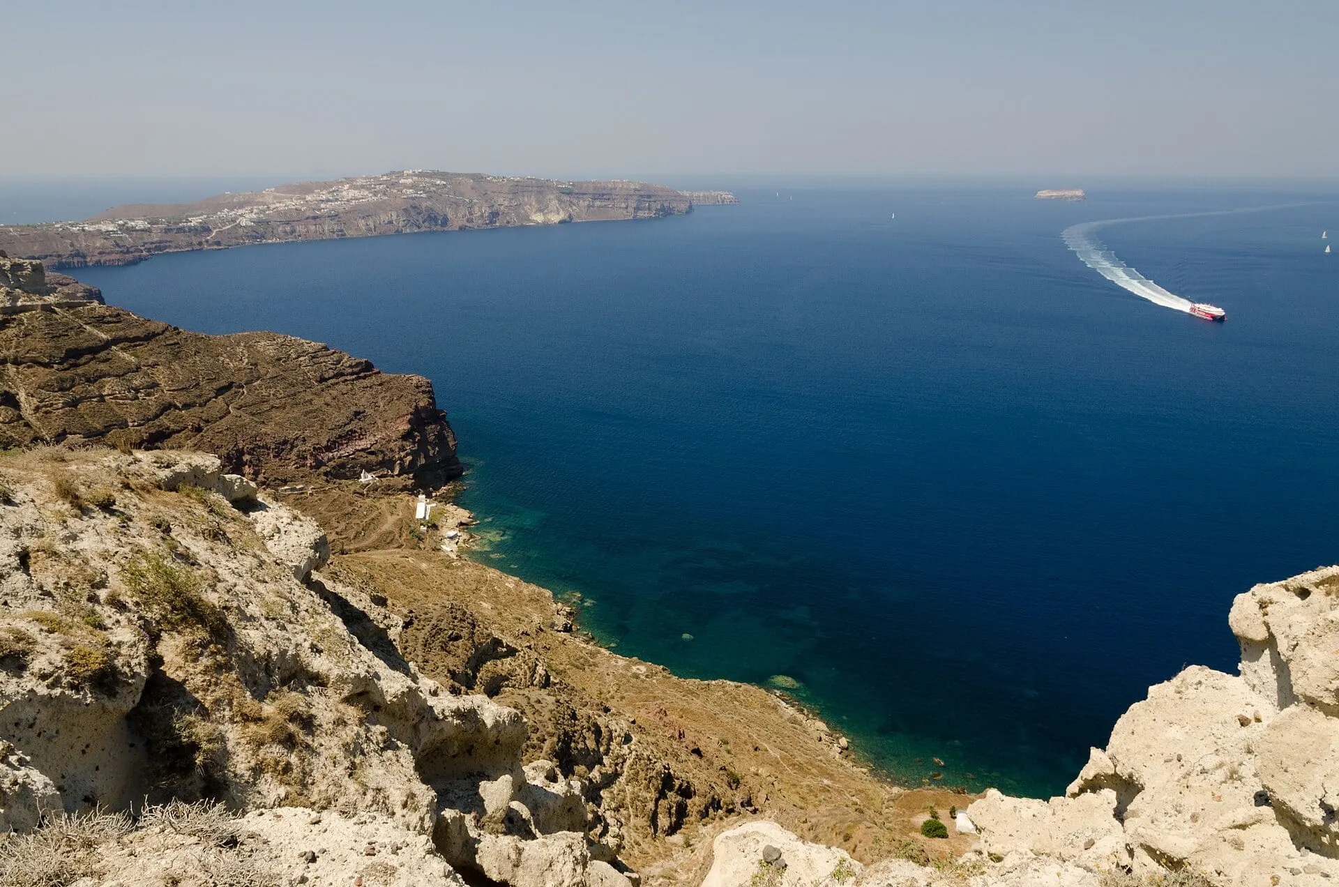 Eine Schnellfähre zieht ihr Kielwasser durch die Caldera von Santorini, von der Klippe bei Athinios aus gesehen.
