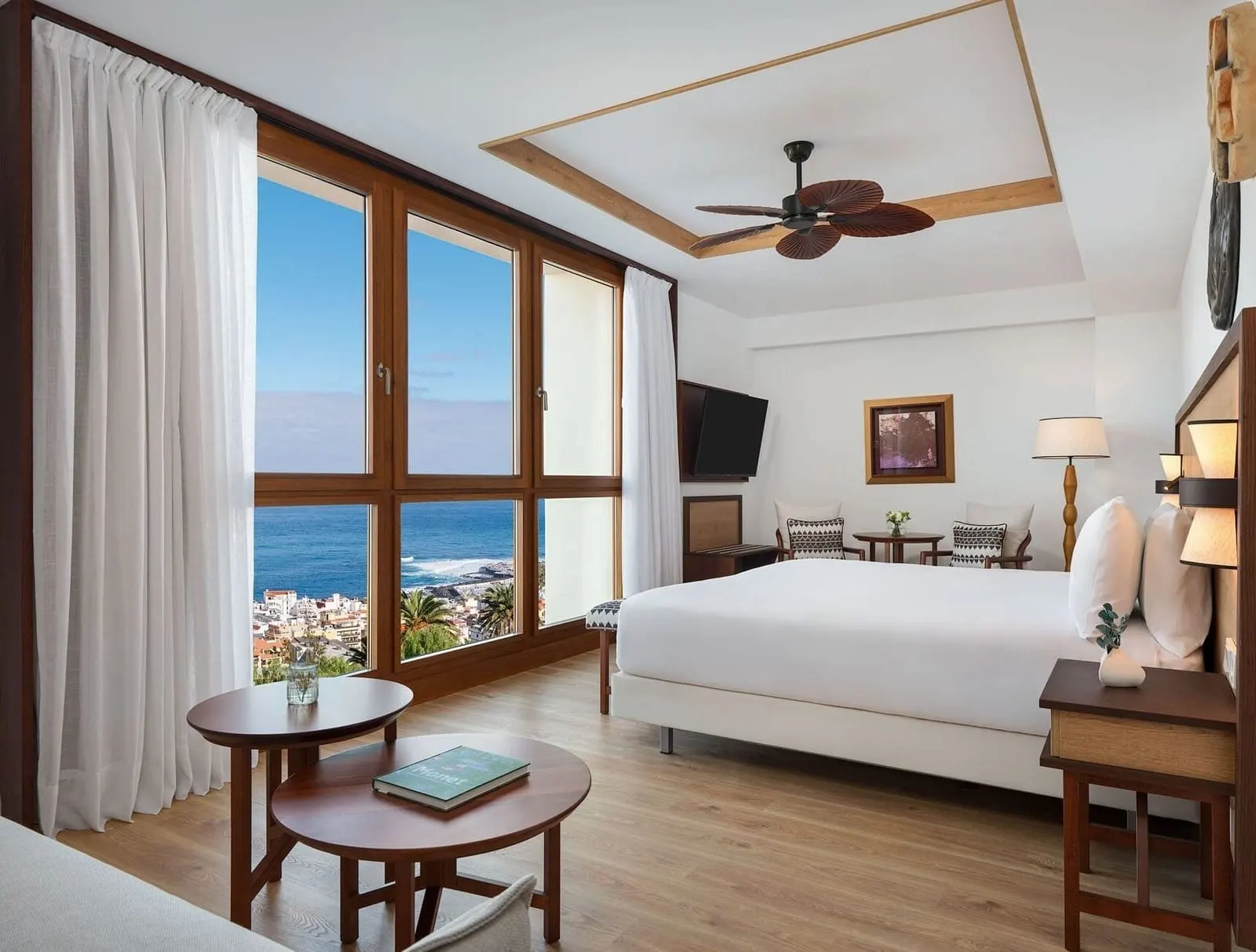 Junior Suite Ocean View at Gran Hotel Taoro: the bed and a sitting area beside tall windows onto the sea
