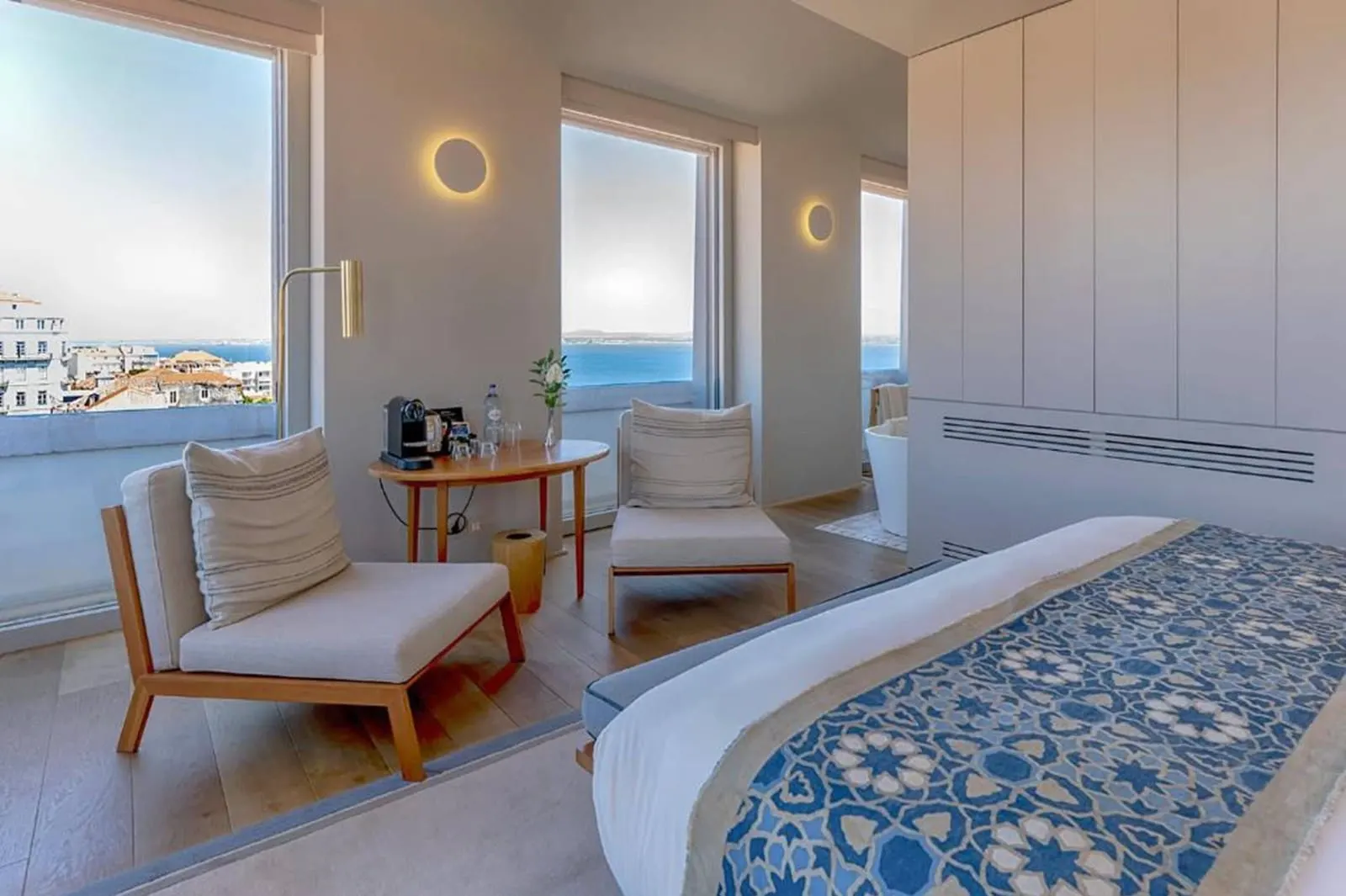 Superior Room with River View at Verride Palácio Santa Catarina: armchairs by corner windows over the river, and the bed