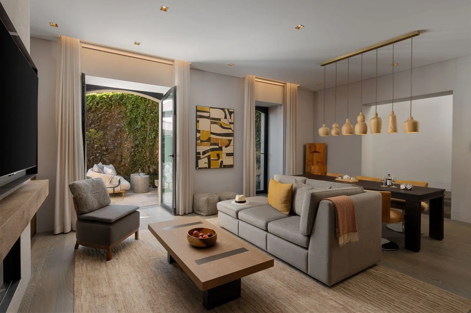 Valley Garden Suite at Six Senses Douro Valley: a sofa, a dining table and doors open to a terrace with a green wall