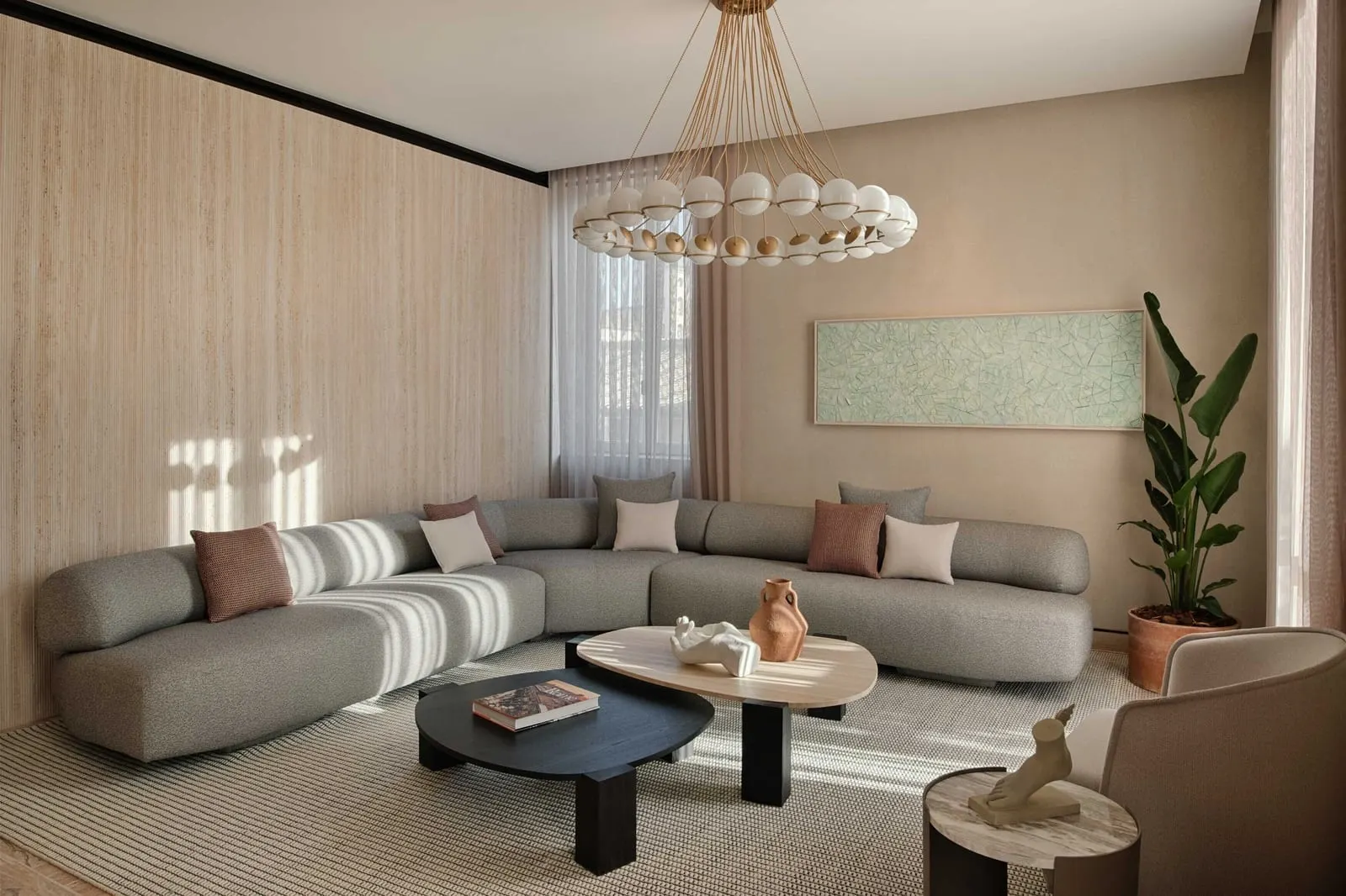 Lata Suite at Six Senses Rome: the living room with a long curved sofa, low tables and a globe chandelier
