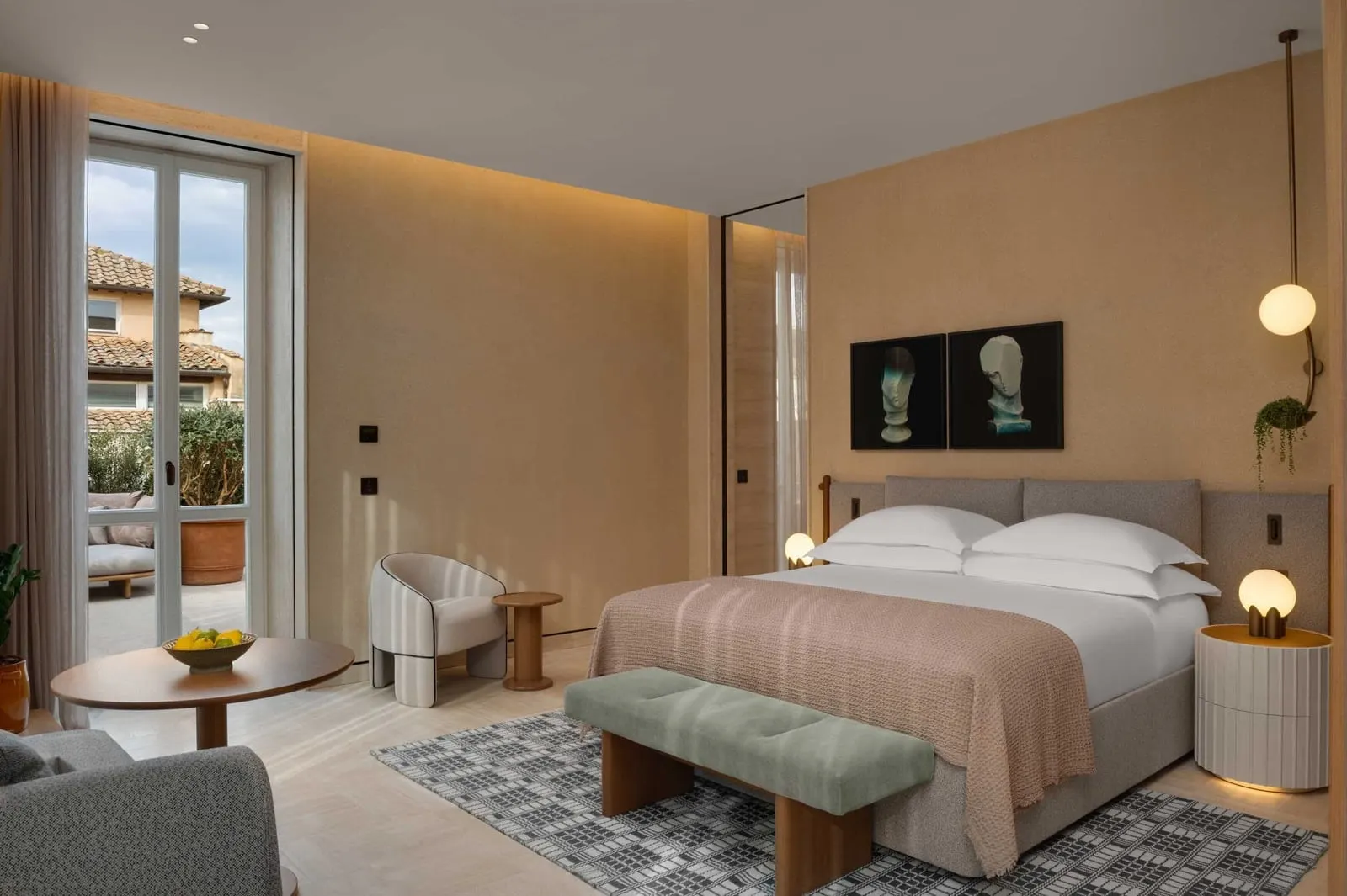 Terrace Junior Suite at Six Senses Rome: the bed, an armchair and glass doors onto the terrace