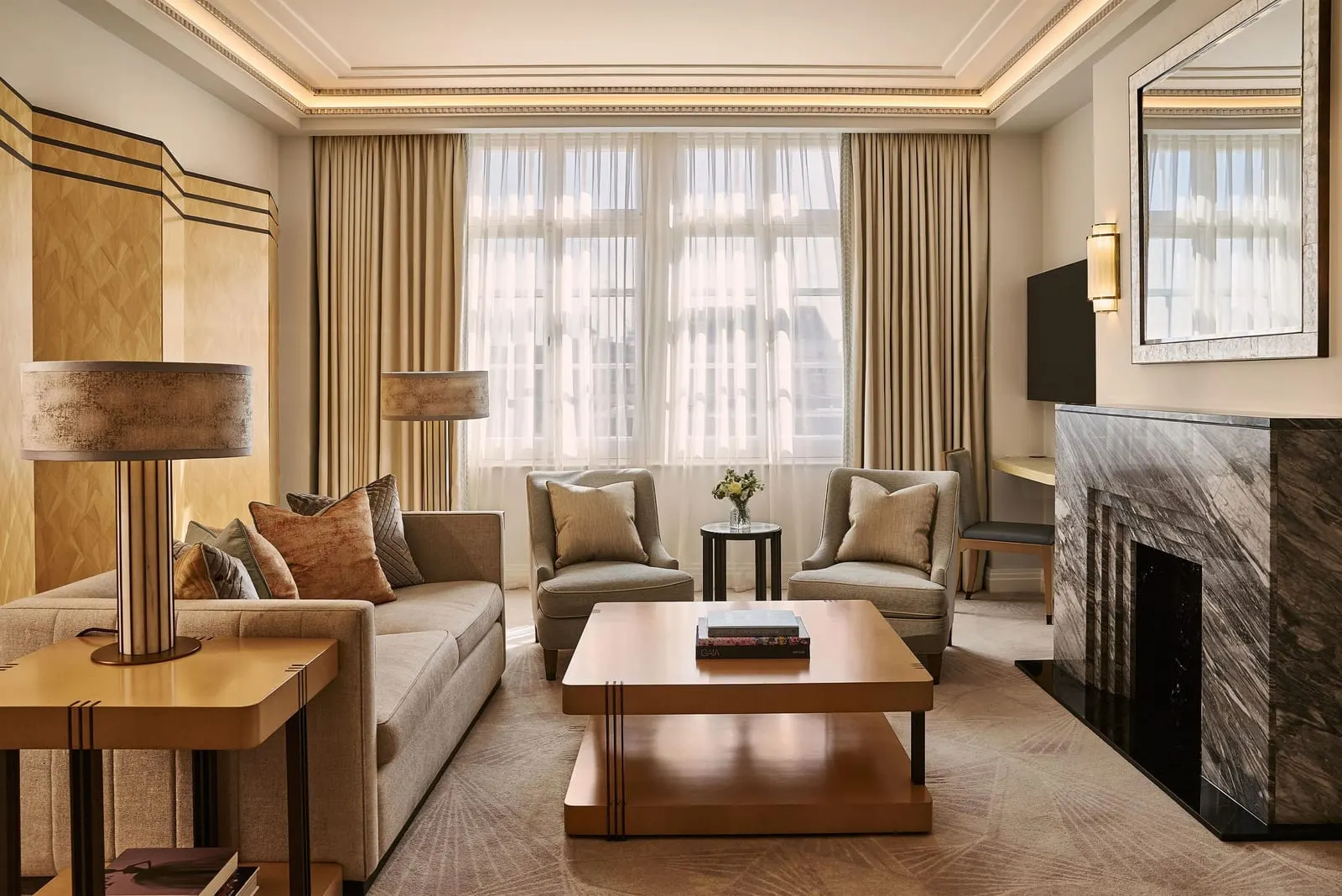 Mayfair Suite at Claridge's: the living room with a dark marble fireplace, a sofa and two armchairs