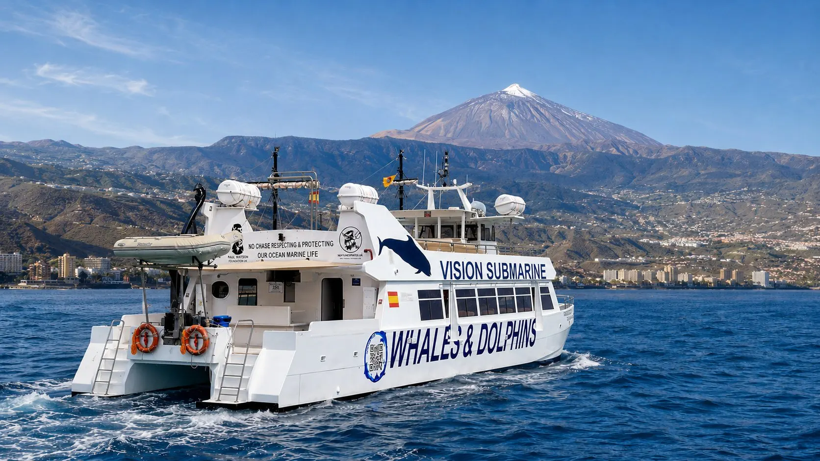 The white Vision Submarine catamaran at sea off Tenerife, with Mount Teide behind