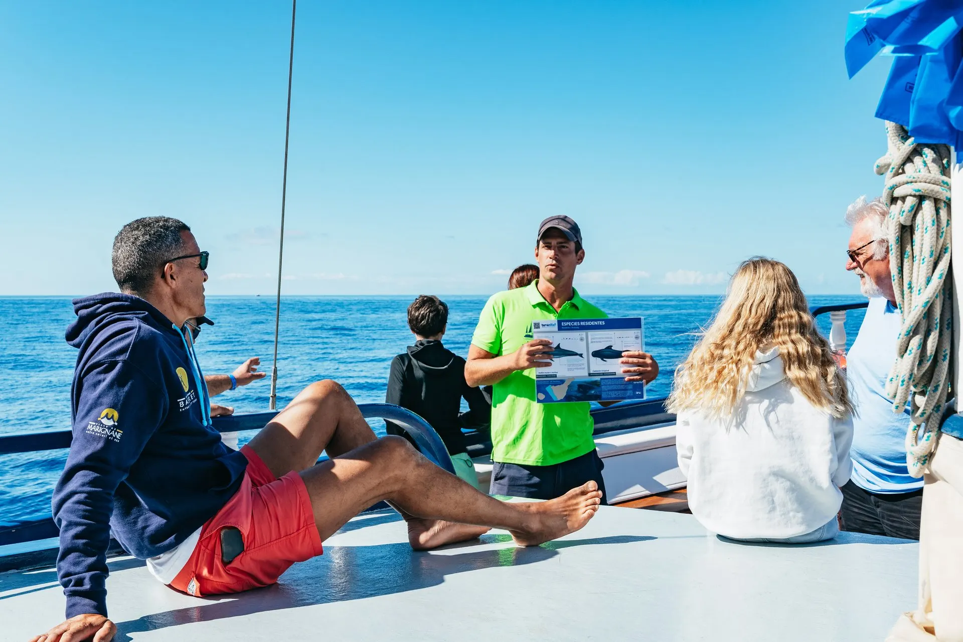 Passengers on the catamaran's deck listening to the guide