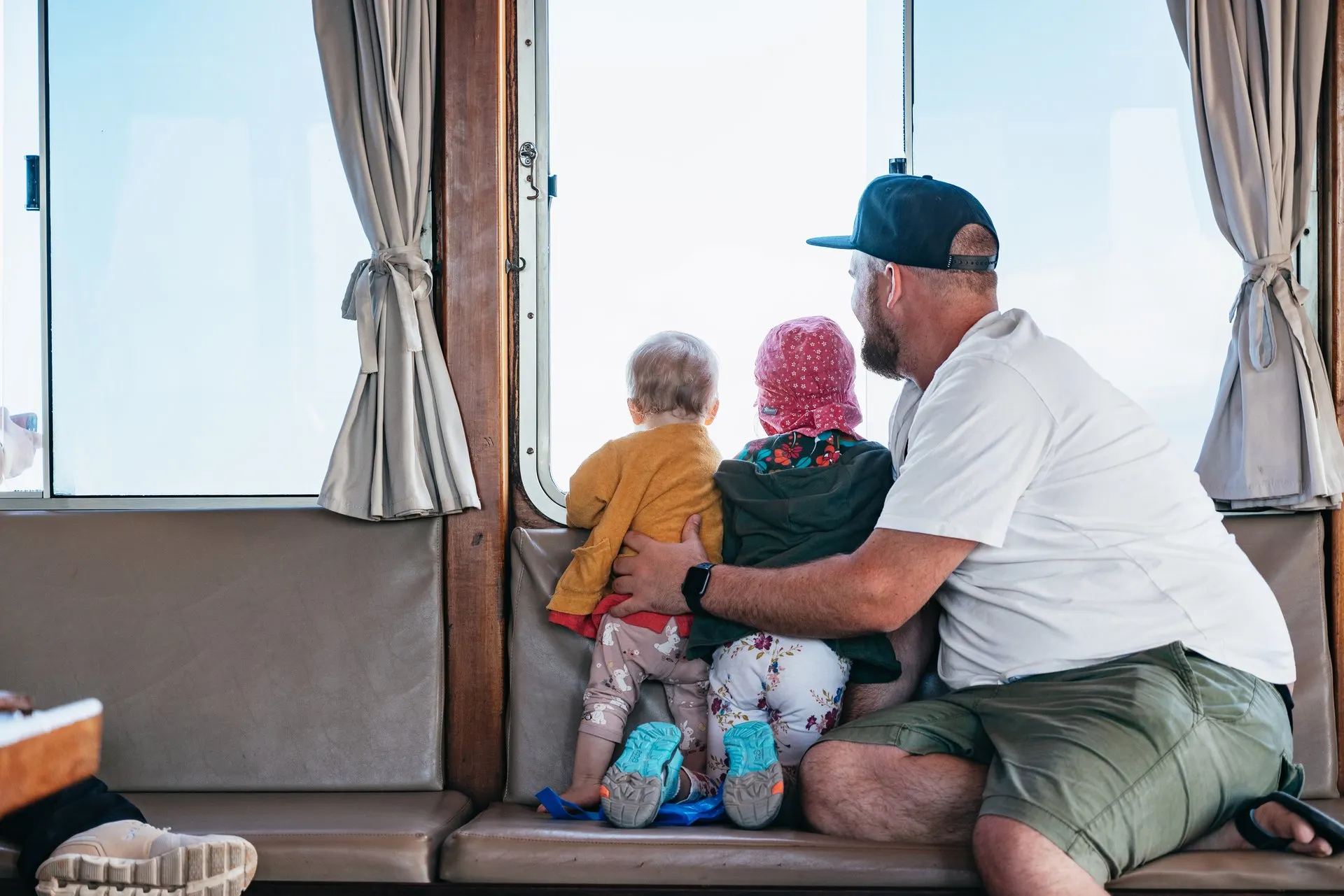 A family watching the sea from the catamaran's cabin